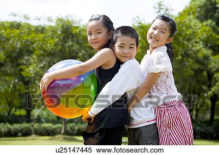 Three children embracing together with a ball and looking at the camera View Large Photo Image Stock Photography - Three children embracing together with a ball and looking at the camera. Fotosearch