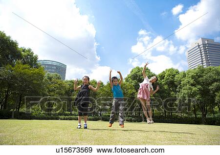 Stock Photo - Three children jumping in mid-air with arms outstretched. Fotosearch