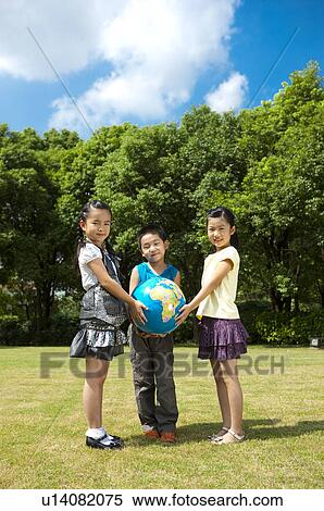 Three children standing on the lawn and holding the globe together View Large Photo Image Stock Photography - Three children standing on the lawn and holding the globe together. Fotosearch