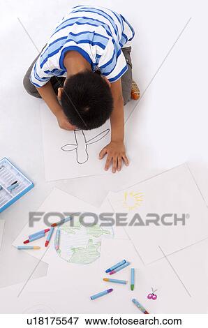Stock Photo - Child, Boy drawing and looking down. Fotosearch