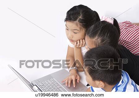 Child, Children lying on front and using laptop together View Large Photo Image Stock Photograph - Child, Children lying on front and using laptop together. Fotosearch