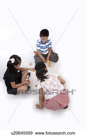 Stock Photo - Child, Children sitting on the floor and playing toy bricks together. Fotosearch