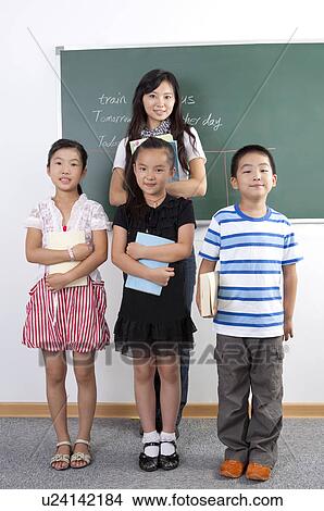 Child, Children standing and holding books with teacher in the classroom View Large Photo Image Picture - Child, Children standing and holding books with teacher in the classroom. Fotosearch