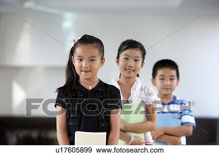 Child, Children standing in a row and holding book with smile View Large Photo Image Stock Photo - Child, Children standing in a row and holding book with smile. Fotosearch
