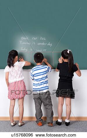 Child, Children standing in a row and writing on the blackboard together View Large Photo Image Stock Photograph - Child, Children standing in a row and writing on the blackboard together. Fotosearch