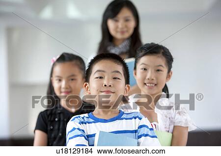 Picture - Child, Children standing with teacher standing behind and smiling. Fotosearch