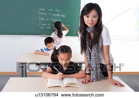 Child, Teacher teaching children and looking at the camera View Large Photo Image Picture - Child, Teacher teaching children and looking at the camera. Fotosearch