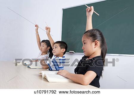 Child, Three children learning in the classroom with hands raised View Large Photo Image Stock Image - Child, Three children learning in the classroom with hands raised. Fotosearch