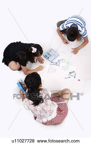 Stock Photo - Child, Three children sitting and drawing on the floor together. Fotosearch