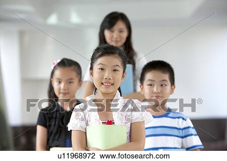 Stock Image - Child, Three children standing with teacher. Fotosearch