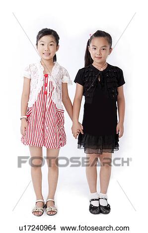 Child, Two girls standing and holding hands together View Large Photo Image Picture - Child, Two girls standing and holding hands together. Fotosearch