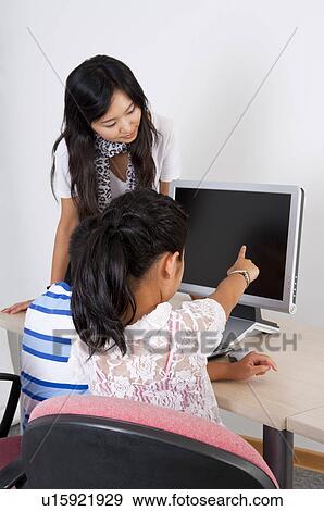 Stock Photo - Child, Young teacher teaching and looking at the laptop with children. Fotosearch