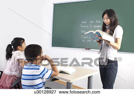Stock Photo - Child, Young teacher teaching and children learning in the classroom. Fotosearch