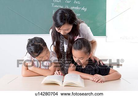 Child, Young teacher teaching children and reading book together View Large Photo Image Picture - Child, Young teacher teaching children and reading book together. Fotosearch