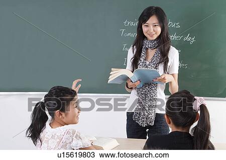 Child, Young teacher teaching children and smiling in the classroom View Large Photo Image Stock Image - Child, Young teacher teaching children and smiling in the classroom. Fotosearch