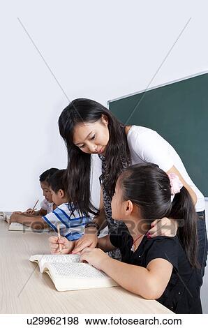 Stock Photo - Child, Young teacher teaching children in the classroom. Fotosearch