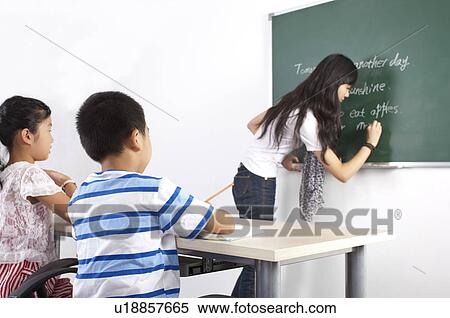 Child, Young teacher teaching children and writing on the blackboard View Large Photo Image Stock Photography - Child, Young teacher teaching children and writing on the blackboard. Fotosearch