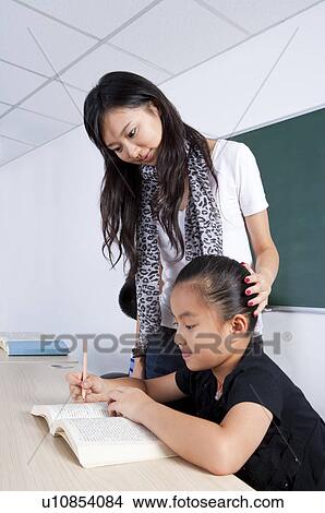 Child, Young teacher teaching girl for guidance View Large Photo Image Picture - Child, Young teacher teaching girl for guidance. Fotosearch