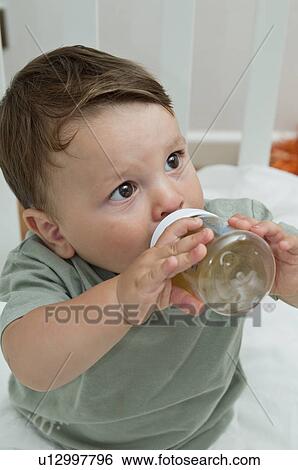 Baby boy drinking from bottle View Large Photo Image Stock Photograph - Baby boy drinking from bottle. Fotosearch
