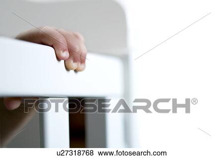 Baby's hand on crib View Large Photo Image Stock Photo - Baby's hand on crib. Fotosearch