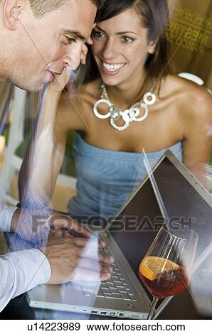 Couple sitting at laptop View Large Photo Image Stock Photo - Couple sitting at laptop. Fotosearch