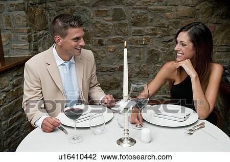 Couple sitting at restaurant table View Large Photo Image Stock Image - Couple sitting at restaurant table. Fotosearch