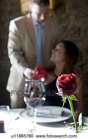 Stock Image - Young man surprising young woman with a present. Fotosearch