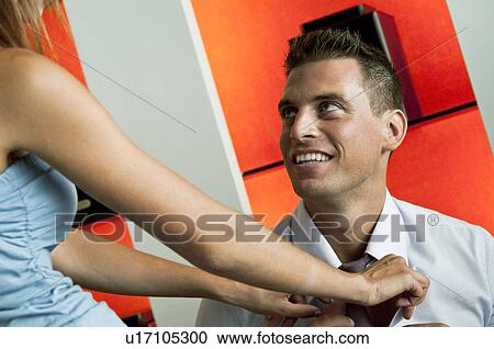 Young woman adjusting young man's tie View Large Photo Image Stock Image - Young woman adjusting young man's tie. Fotosearch