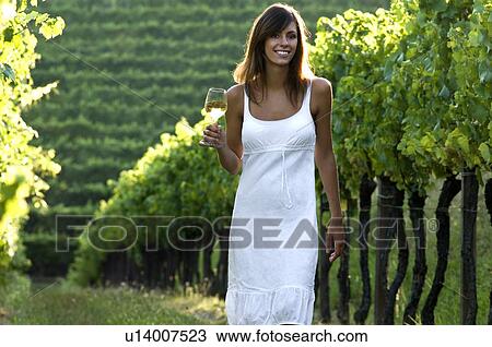 Young woman in vineyard holding wine glass View Large Photo Image Stock Image - Young woman in vineyard holding wine glass. Fotosearch