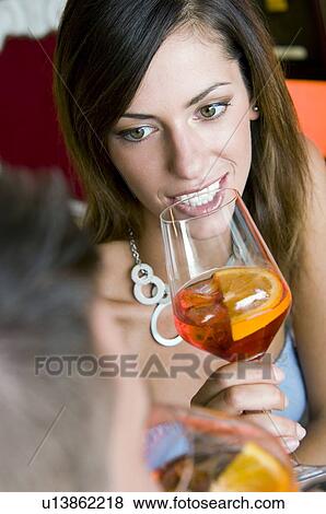 Young woman with a glass of orange wine and young man View Large Photo Image Stock Photo - Young woman with a glass of orange wine and young man. Fotosearch