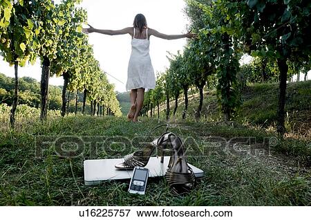 Young woman in vineyard with high heel shoes, mobile, and laptop in foreground View Large Photo Image Stock Photo - Young woman in vineyard with high heel shoes, mobile, and laptop in foreground. Fotosearch