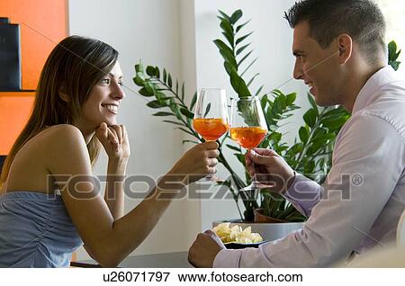 Couple toasting with orange wine View Large Photo Image Stock Photo - Couple toasting with orange wine. Fotosearch