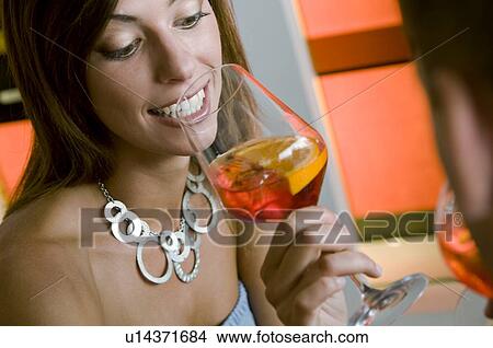 Young woman with a glass of orange wine and young man View Large Photo Image Picture - Young woman with a glass of orange wine and young man. Fotosearch