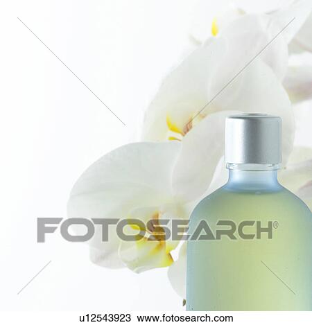 Stock Image - Cosmetic bottle and orchid blossoms. Fotosearch