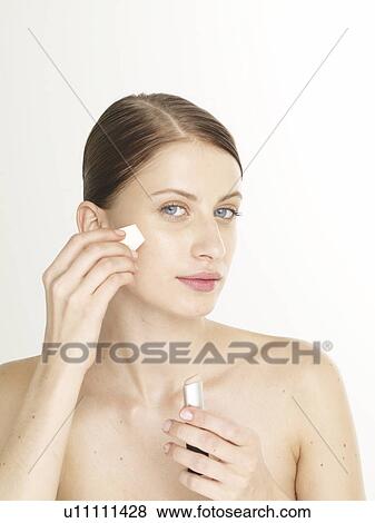 Woman is making up her face View Large Photo Image Stock Photo - Woman is making up her face. Fotosearch