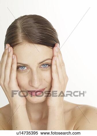 Stock Photography - Woman is putting hands on her face. Fotosearch
