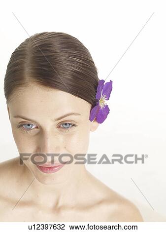 Stock Image - Woman with a lilac blossom in her hair. Fotosearch
