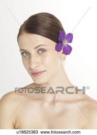 Stock Image - Woman with a lilac blossom in her hair. Fotosearch
