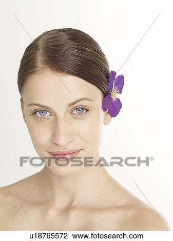 Stock Image - Woman with a lilac blossom in her hair. Fotosearch