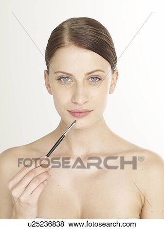 Stock Photo - Woman with a lip brush. Fotosearch