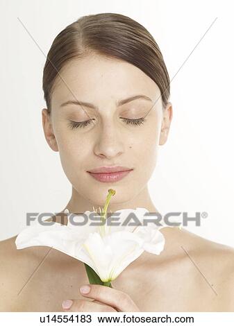 Woman with a white lily blossom is closing her eyes View Large Photo Image Stock Image - Woman with a white lily blossom is closing her eyes. Fotosearch