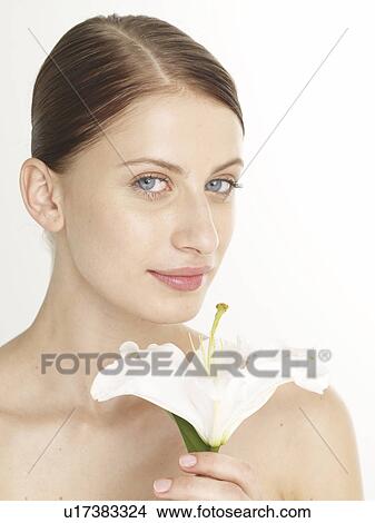 Woman with a white lily blossom View Large Photo Image Picture - Woman with a white lily blossom. Fotosearch
