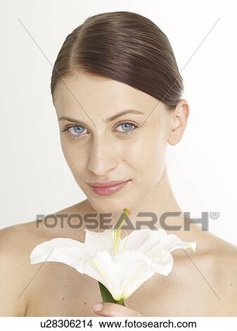 Picture - Woman with a white lily blossom. Fotosearch