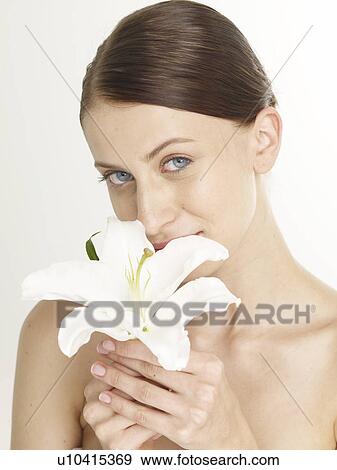 Stock Photo - Woman with a white lily blossom. Fotosearch