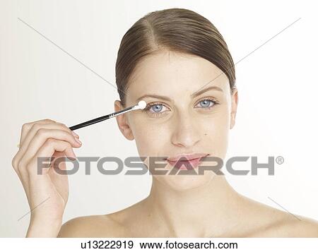 Stock Photo - Woman with an eye shadow brush. Fotosearch