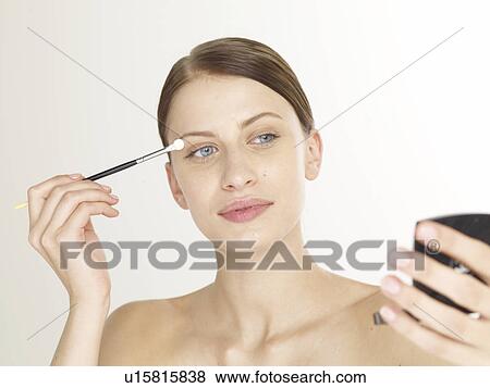 Stock Photo - Woman with an eye shadow brush. Fotosearch