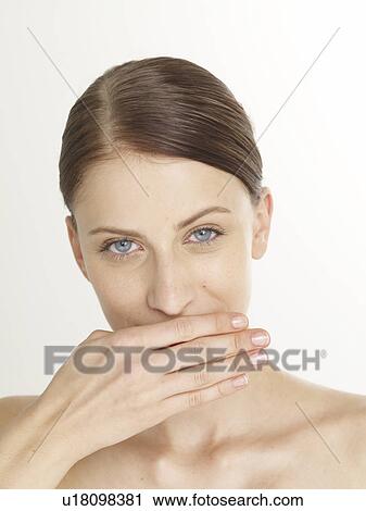 Stock Image - Woman with her hand in front of her mouth. Fotosearch