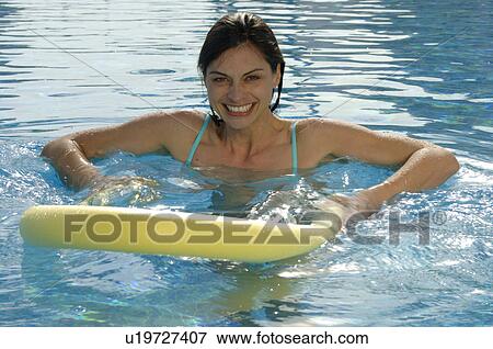 Stock Photo - Couple in the swimming pool with rings. Fotosearch