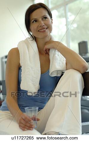 Stock Photography - Woman in the gym with a glass of water. Fotosearch