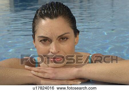 Stock Photograph - Woman in the swimming pool at the border. Fotosearch
